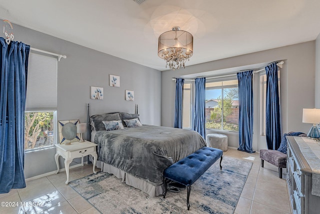 tiled bedroom with an inviting chandelier