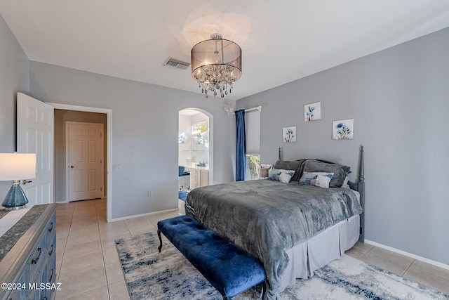 bedroom featuring connected bathroom, a notable chandelier, and light tile patterned flooring