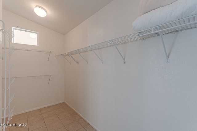 walk in closet featuring tile patterned flooring and lofted ceiling