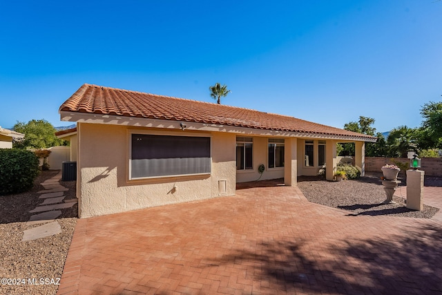 rear view of house with central AC unit and a patio area