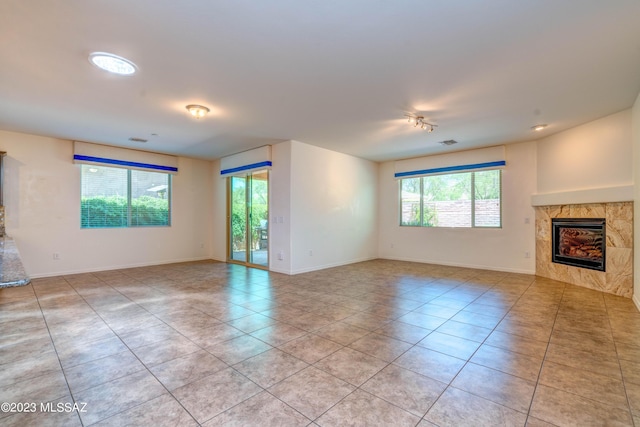 unfurnished living room with light tile patterned flooring and a tiled fireplace