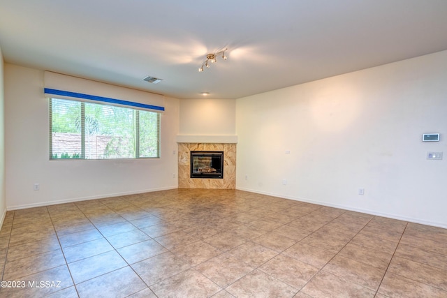 unfurnished living room featuring a high end fireplace and light tile patterned floors