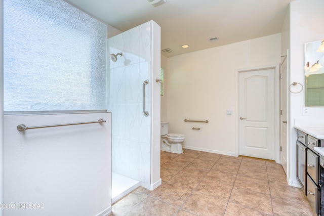 bathroom featuring a tile shower, toilet, and vanity