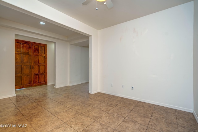 tiled spare room featuring ceiling fan