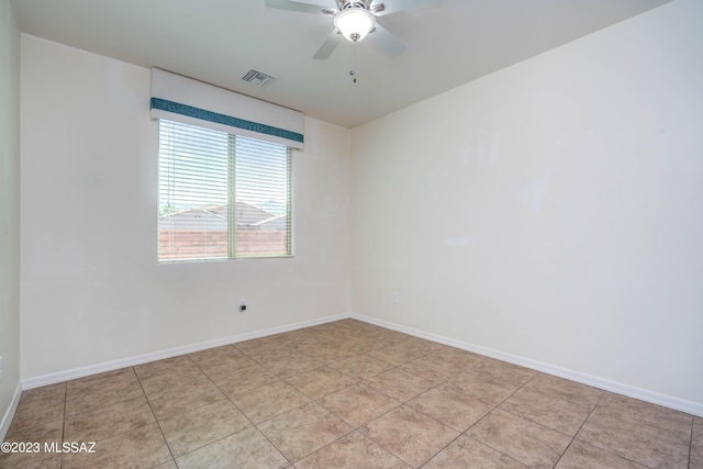 tiled spare room with ceiling fan