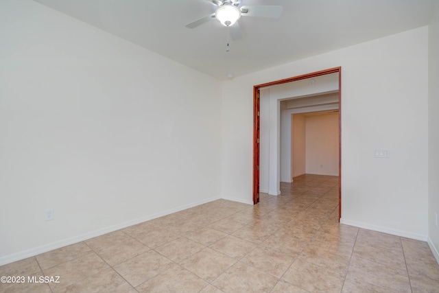 tiled spare room with ceiling fan