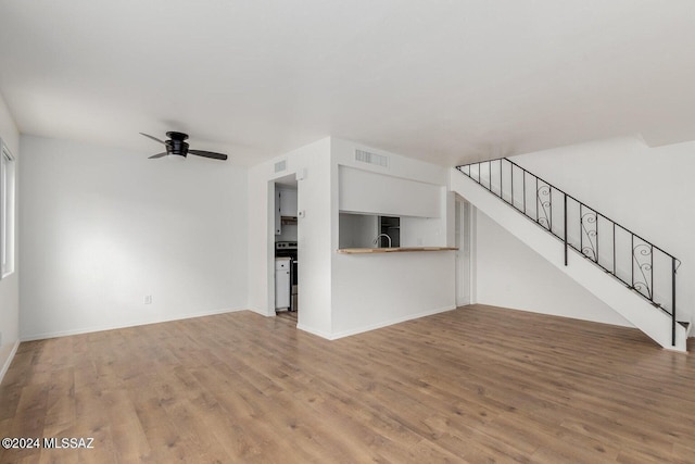 unfurnished living room with ceiling fan and light hardwood / wood-style flooring