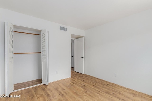 unfurnished bedroom featuring light hardwood / wood-style floors and a closet