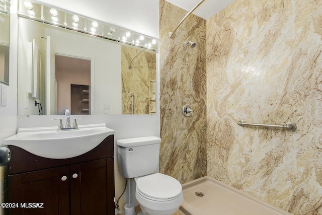 bathroom featuring vanity, toilet, and tiled shower