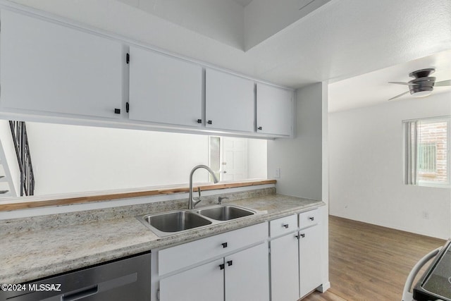 kitchen with stainless steel dishwasher, light hardwood / wood-style floors, sink, and white cabinets