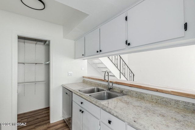 kitchen featuring sink, stainless steel dishwasher, white cabinets, and dark wood-type flooring