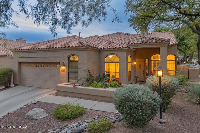 mediterranean / spanish-style home with a garage