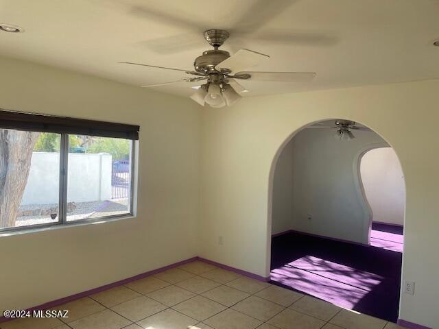 tiled spare room with ceiling fan