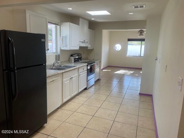 kitchen with black refrigerator, a healthy amount of sunlight, electric range, dishwasher, and white cabinetry