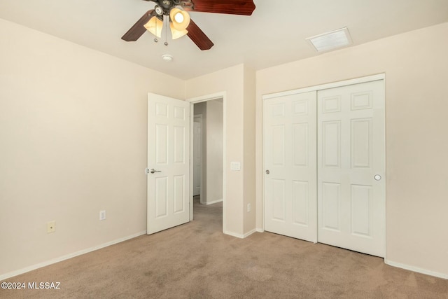 unfurnished bedroom featuring ceiling fan, a closet, and light colored carpet