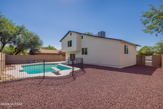 view of swimming pool featuring a diving board, a patio area, and central air condition unit