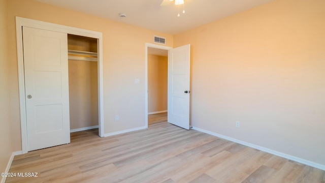 unfurnished bedroom with light hardwood / wood-style flooring, a closet, and ceiling fan