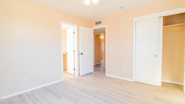 unfurnished bedroom with light hardwood / wood-style floors and a closet