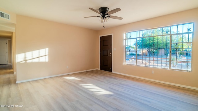 empty room with ceiling fan and light hardwood / wood-style flooring