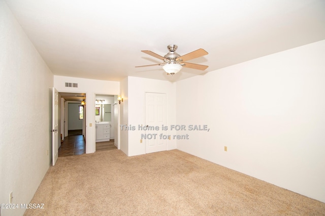 unfurnished room featuring carpet, visible vents, and a ceiling fan