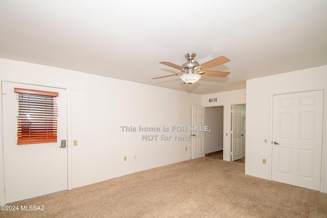 unfurnished bedroom with carpet floors, visible vents, and a ceiling fan