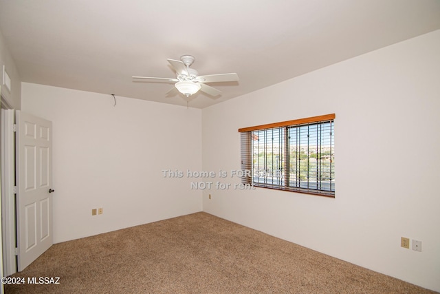 spare room featuring carpet and a ceiling fan