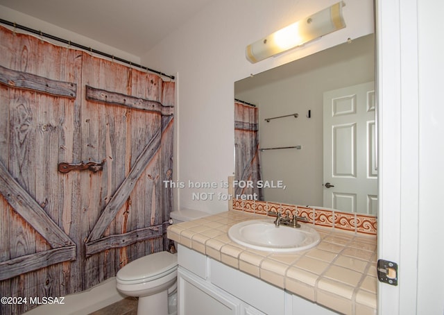 bathroom with toilet, a shower with curtain, and vanity