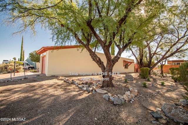 view of property exterior with driveway, an attached garage, and stucco siding