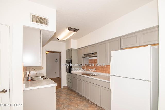 kitchen with under cabinet range hood, gray cabinetry, a sink, visible vents, and black appliances