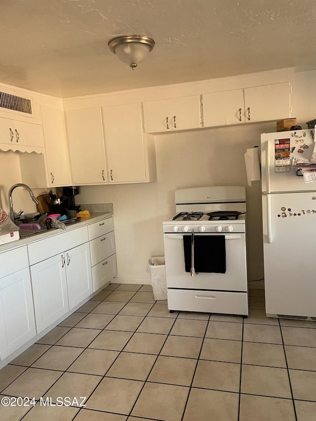 kitchen with white cabinets, white appliances, sink, and light tile patterned floors