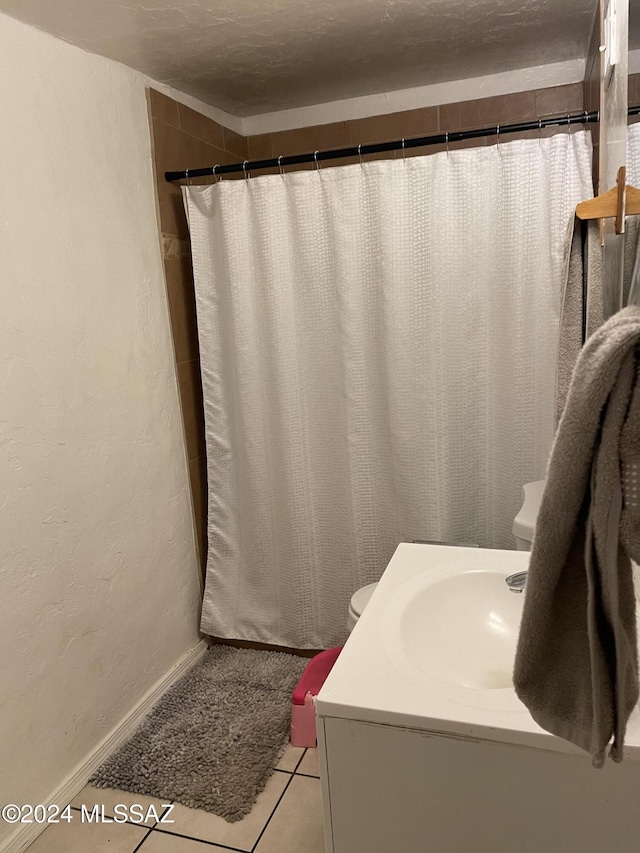 bathroom with tile patterned flooring, curtained shower, and sink