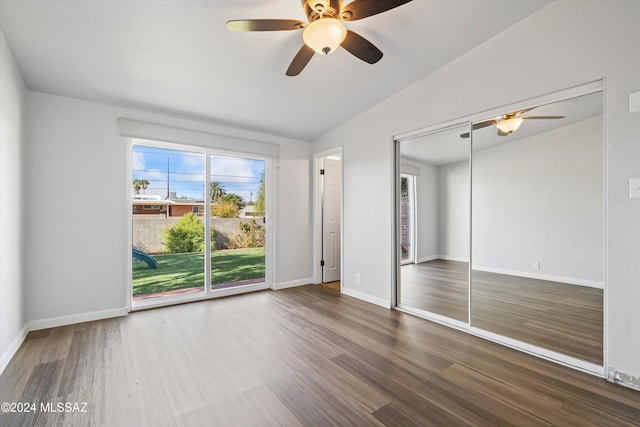 unfurnished bedroom with lofted ceiling, access to outside, ceiling fan, wood-type flooring, and a closet