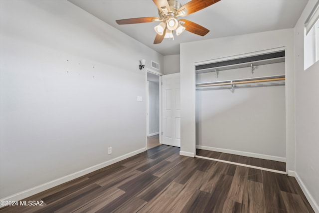 unfurnished bedroom with dark hardwood / wood-style flooring, a closet, and ceiling fan