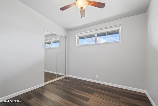 unfurnished bedroom with dark hardwood / wood-style flooring, ceiling fan, and a closet