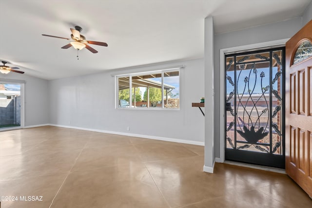 entrance foyer with ceiling fan and concrete flooring