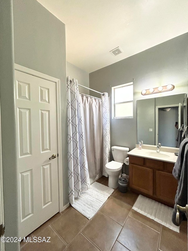 bathroom with tile patterned flooring, vanity, curtained shower, and toilet