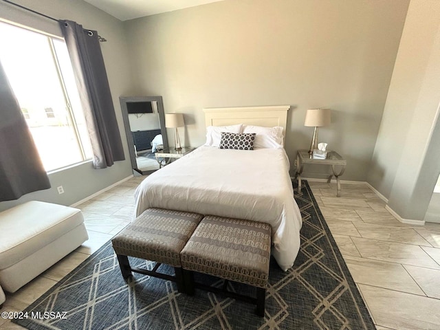 bedroom with tile patterned floors and multiple windows