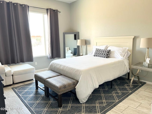 bedroom with hardwood / wood-style flooring and multiple windows