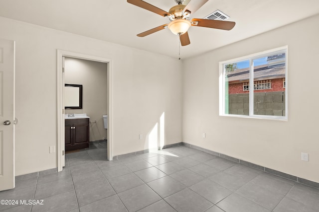 empty room featuring ceiling fan, sink, and light tile patterned flooring