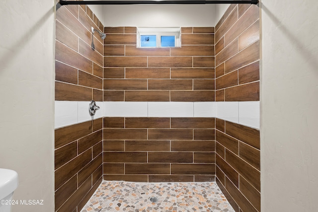 bathroom with toilet and tiled shower