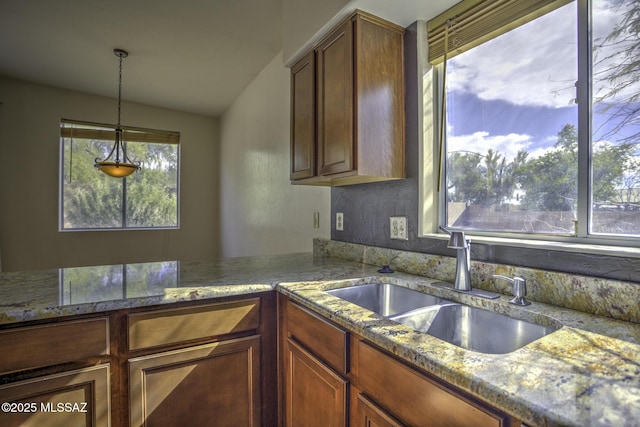 kitchen featuring vaulted ceiling, decorative light fixtures, and sink