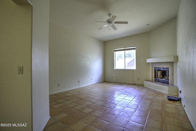 unfurnished living room featuring a tiled fireplace, light tile patterned floors, and ceiling fan