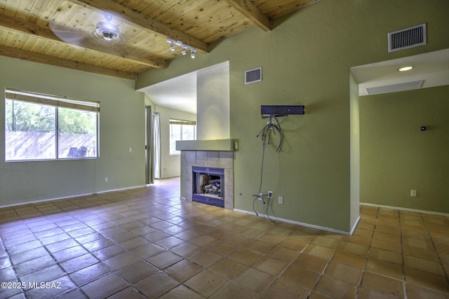 unfurnished living room featuring beamed ceiling, tile patterned flooring, and wooden ceiling