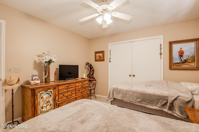 bedroom featuring ceiling fan, a closet, and a textured ceiling