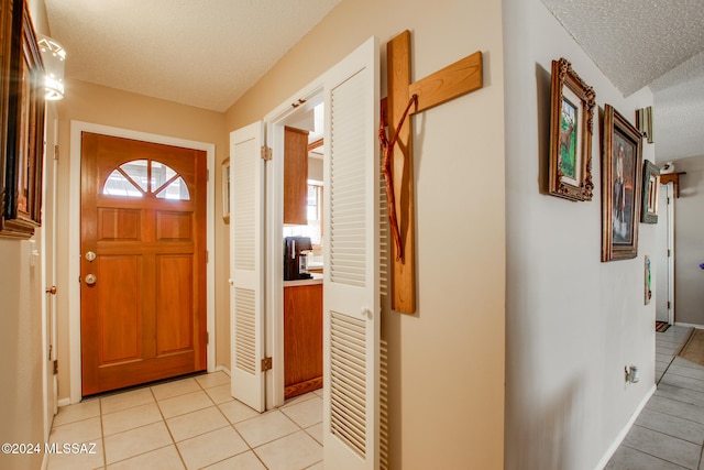 tiled foyer with a textured ceiling and a wealth of natural light