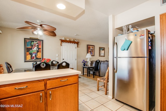 kitchen with stainless steel fridge, a textured ceiling, light tile patterned floors, and ceiling fan