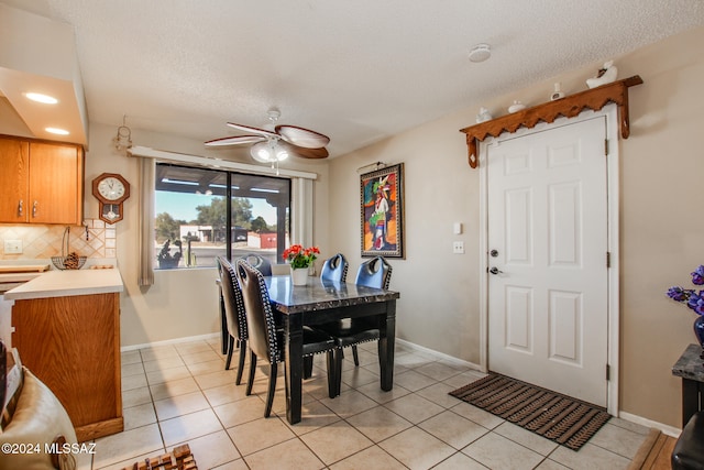 tiled dining area with a textured ceiling and ceiling fan