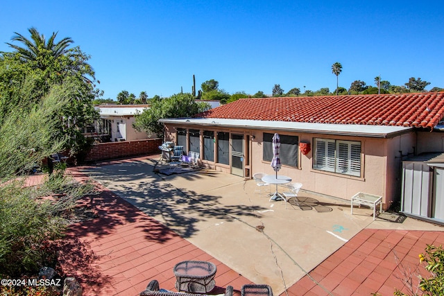 rear view of house with a patio area and a sunroom