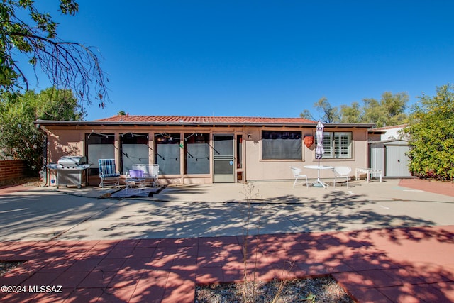 view of front of property featuring a patio area and a storage unit