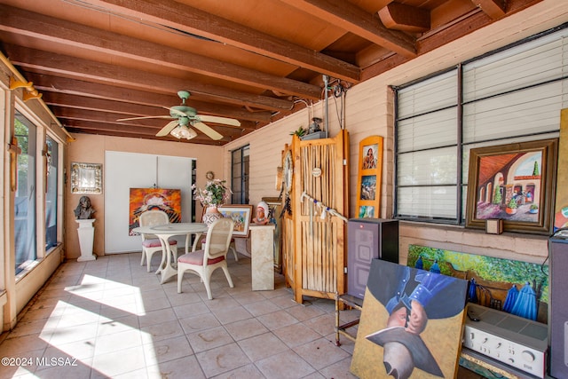 sunroom featuring beam ceiling and ceiling fan